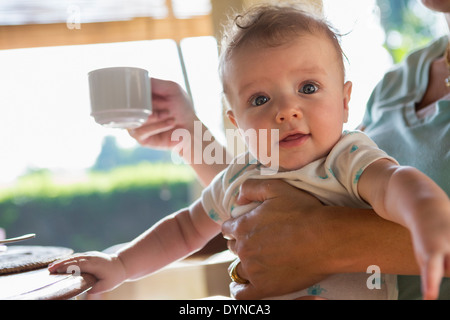 Kaukasische Mutter halten Baby beim Frühstück Stockfoto