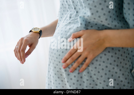 Schwanger kaukasischen Frau Timing Kontraktionen im Krankenhaus Stockfoto