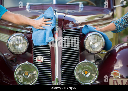 Eine männliche und weibliche Hand abwischen der Windschutzscheibe historischen Buick in Pompano Beach, FL Stockfoto