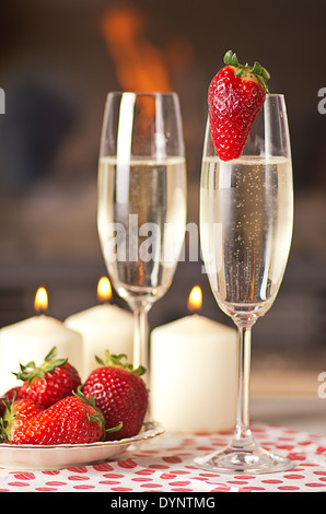 Champagner, Erdbeeren und Kerzen für einen romantischen Abend. Stockfoto