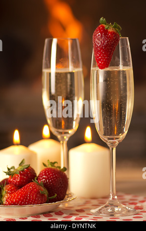 Champagner, Erdbeeren und Kerzen für einen romantischen Abend. Stockfoto