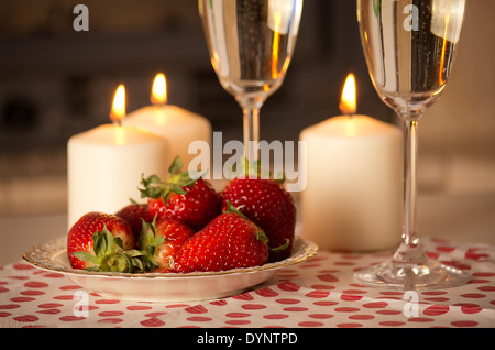 Champagner, Erdbeeren und Kerzen für einen romantischen Abend. Stockfoto