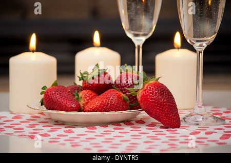 Champagner, Erdbeeren und Kerzen für einen romantischen Abend. Stockfoto