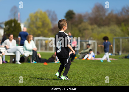Jungen Fußball spielen, während der Sommerzeit. Marken sind entfernt worden. Stockfoto