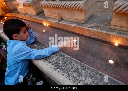 Ein armenischer Junge zündet am 24. APRIL 2014 Kerzen an der Gedenkstätte für den armenischen Völkermord an, während der Gedenkfeier zum 99. Jahrestag des armenischen Völkermordes in der Altstadt von Ostjerusalem, Israel, am Armenischen Viertel, gefeiert wird. Der Tag des Gedenkens an den Völkermord oder der Tag des Gedenkens an den Völkermord wird von Armeniern in verstreuten Gemeinden auf der ganzen Welt am 24. April begangen. Sie wird jährlich zum Gedenken an die Opfer des armenischen Völkermordes von 1915 bis 1923 abgehalten. Stockfoto