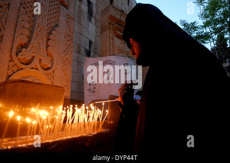 Ein armenischer Priester zündet am 24. APRIL 2014 Kerzen an der Gedenkstätte für den armenischen Völkermord an, während der Gedenkfeier zum 99. Jahrestag des armenischen Völkermordes in der Altstadt von Ostjerusalem, Israel, am Armenischen Viertel, gefeiert wird. Der Tag des Gedenkens an den Völkermord oder der Tag des Gedenkens an den Völkermord wird von Armeniern in verstreuten Gemeinden auf der ganzen Welt am 24. April begangen. Sie wird jährlich zum Gedenken an die Opfer des armenischen Völkermordes von 1915 bis 1923 abgehalten. Stockfoto