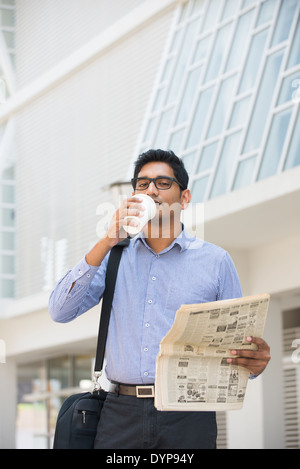 asiatische, indische Geschäftsmann mit Kaffee und Papiere Stockfoto