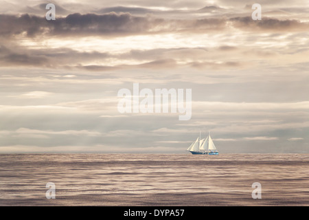 Träume und Freiheit... Segelboot auf dem offenen Meer bei Sonnenuntergang. Stockfoto