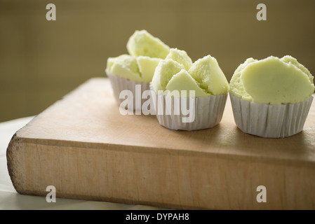 Drei grüne Thai Tasse Kuchen auf einem hölzernen Block angezeigt. Stockfoto