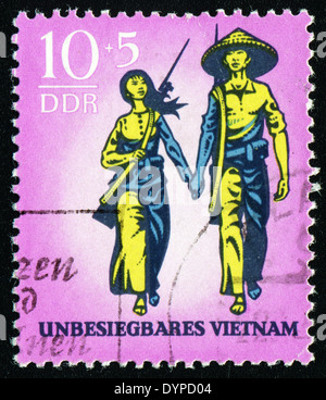 DDR - ca. 1969: Eine Briefmarke gedruckt in Deutschland, zeigt Vietnamesisch mit Waffen, ca. 1969 Stockfoto