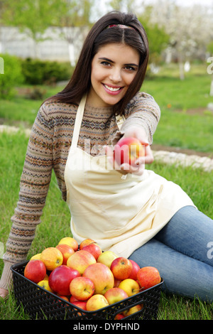 Glückliche Frau geben Sie Apple gegen Grasgrün Stockfoto