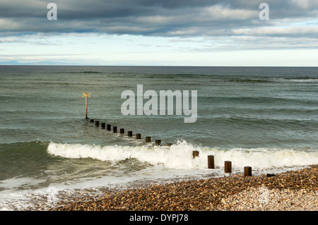 WELLEN BRECHEN SICH AM STRAND VON FINDHORN MORAY SCHOTTLAND ÜBER BUHNE Stockfoto