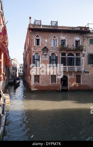 Vertikale Schuss des gotischen Gebäudes und sonnigen Himmel an einem ruhigen Kanal in Venedig Stockfoto