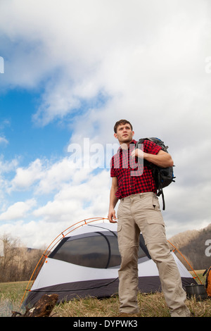 Wanderer richtet Camp mit Zelten und Feuerstelle Stockfoto