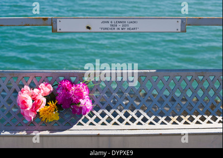 Gedenktafeln mit Blumen auf Bangor Pier über die Menaistraße bei Bangor Gwynedd North Wales UK Stockfoto