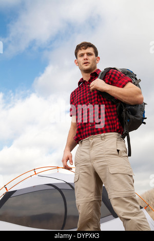 Wanderer richtet Camp mit Zelten und Feuerstelle Stockfoto