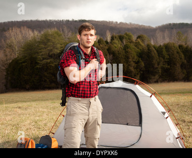 Wanderer richtet Camp mit Zelten und Feuerstelle Stockfoto