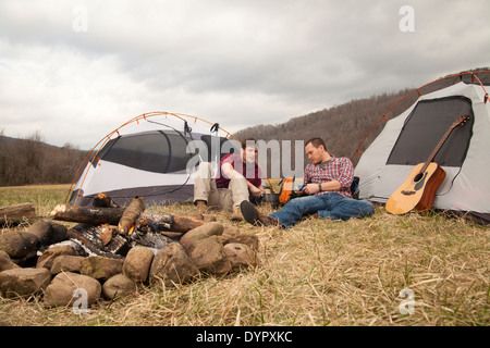 Wanderer beim Abendessen am Feuer auf dem Campingplatz Stockfoto