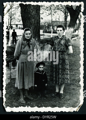 UdSSR - ca. 1954: Ein antikes Foto zeigt zwei Frauen stehen in der Nähe eines Baumes mit einem kleinen Jungen, 1954 Stockfoto