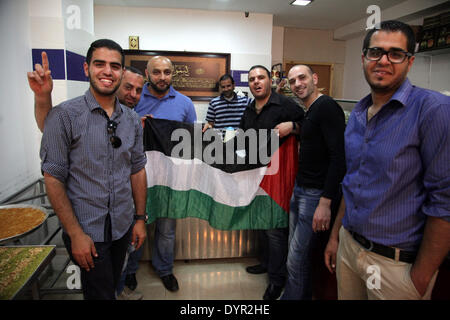 Jerusalem, Jerusalem, Palästina. 24. April 2014. Palästinenser halten ihrer Nationalflagge während der Feier einer Vereinbarung, einem siebenjährigen Schisma zwischen der Fatah und Hamas Gruppen in Jerusalem 24. April 2014 zu heilen. Die Einigung bei Gesprächen in Gaza-Stadt, die in den frühen Morgenstunden des morgens zwischen Hamas-Führer und eine Palästinensische Befreiungsorganisation (PLO) Delegation unter der Leitung von Azzam al-Ahmad Credit fortgesetzt: Saeed Qaq/APA Images/ZUMAPRESS.com/Alamy Live News Stockfoto