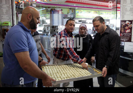 Jerusalem, Jerusalem, Palästina. 24. April 2014. Palästinenser verteilen Süßigkeiten während der Feier einer Vereinbarung, einem siebenjährigen Schisma zwischen der Fatah und Hamas Gruppen in Jerusalem 24. April 2014 zu heilen. Die Einigung bei Gesprächen in Gaza-Stadt, die in den frühen Morgenstunden des morgens zwischen Hamas-Führer und eine Palästinensische Befreiungsorganisation (PLO) Delegation unter der Leitung von Azzam al-Ahmad Credit fortgesetzt: Saeed Qaq/APA Images/ZUMAPRESS.com/Alamy Live News Stockfoto