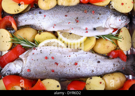 Zwei mariniert Regenbogenforellen mit Paprika, Kartoffeln und Zitrone Stockfoto