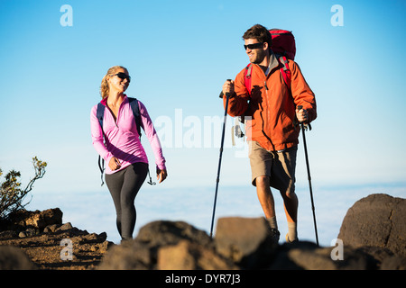 Wandern in den Bergen. Sportliche Brautpaar mit Rucksäcken genießen Wandern im Freien auf schönen Bergweg. Stockfoto