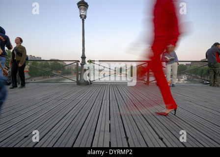 rot gekleidete Frau, die Überquerung der Brücke Pont des Arts, Paris, Frankreich Stockfoto