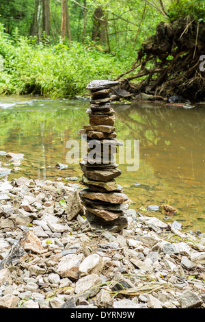 Steinen-Pyramide in der Nähe von kleinen Fluss symbolisiert Zen, Harmonie, Gleichgewicht Stockfoto