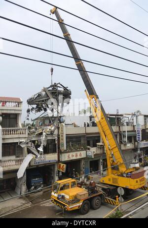 Taoyuan, Taiwan. 25. April 2014. Ein Kran hebt einen militärische Hubschrauber, stürzte in einem Wohnhaus in Taoyuan County, Taiwan Südost, 25. April 2014. Der Absturz verletzt zwei Piloten an Bord, sagte Feuerwehrleute. Keine Explosion oder Feuer aufgetreten. Die beiden verletzten Piloten haben zum Krankenhaus gehetzt worden und sind in einem stabilen Zustand. Bildnachweis: Huang Xiaoyong/Xinhua/Alamy Live-Nachrichten Stockfoto