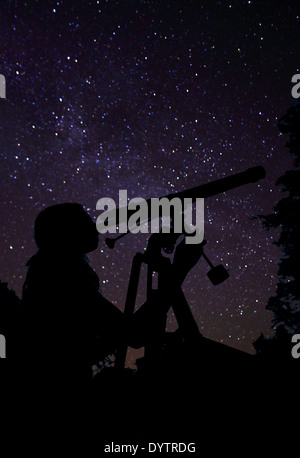 Mädchen auf der Suche durch Teleskop Stockfoto