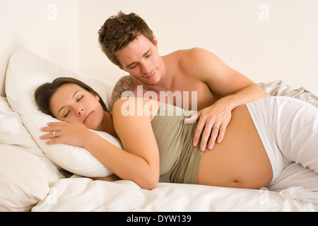 Werdende Paar auf Bett Stockfoto