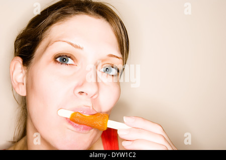 Frau saugt ein Eis am Stiel Stockfoto