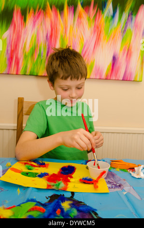 acht Jahre alter Junge Kunst und Handwerk Montage mit Klebstoff Schere und Farbe zu tun. Stockfoto