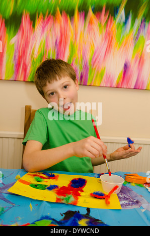 acht Jahre alter Junge Kunst und Handwerk Montage mit Klebstoff Schere und Farbe zu tun. Stockfoto