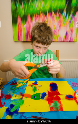 acht Jahre alter Junge Kunst und Handwerk Montage mit Klebstoff Schere und Farbe zu tun. Stockfoto
