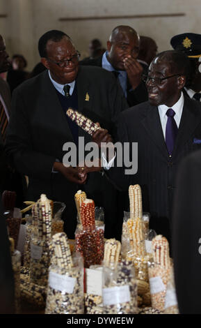 Bulawayo, Simbabwe. 25. April 2014. Zimbabwean President Robert Mugabe (R) schaut auf den Mais auf dem Display in Zimbabwe International Trade Fair (ZITF), premier des Landes jährliche Messe, die seit 55 Jahren in der internationalen Konferenz Center von Bulawayo, Simbabwe, 25. April 2014 stattgefunden hat. Simbabwes Präsident Robert Mugabe beschwichtigte die gemeinsamen Ängste unter den ausländischen Investoren am Freitag mit dem Versprechen, dass seine Regierung würde nicht nutzen und Vermögen der ausländischen Firmen in Simbabwe unter das Gesetz des Landes Indigenisierung zu verstaatlichen. Bildnachweis: Stringer/Xinhua/Alamy Live-Nachrichten Stockfoto