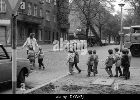 Berlin, DDR, Erzieher über überqueren einer Straße mit einer Gruppe von Kindern Stockfoto