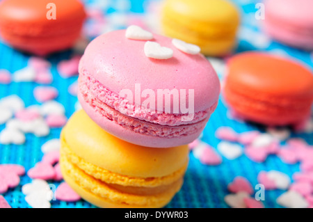 einige appetitlich Macarons mit verschiedenen Farben und Aromen auf blauem Hintergrund Stockfoto