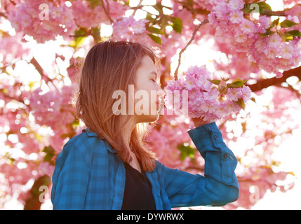 junges Mädchen rosa Blüten riechen Stockfoto