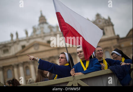 Vatikan, Rom, Italien. 26. April 2014. Polnische Schwestern halten eine polnische Flagge auf dem Petersplatz im Vatikan, 26. April 2014. Rund 1 Million Pilgern und Touristen sind in Rom erwartet, wenn Papst John XXIII. und Papst Johannes Paul II. am 27. April 2014 von Francis Papst heiliggesprochen.  Bildnachweis: MICHAEL KAPPELER/Dpa/Alamy Live News Stockfoto