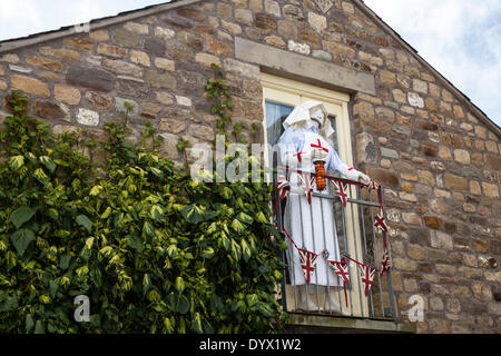 Wray, Lancaster, Großbritannien, 26. April 2014. Rotkreuzschwester auf einem Balkon an der Wray Scarecrow Festival, das am Samstag, 26. April 2014 Für eine Reihe von Veranstaltungen, darunter 10 km Lauf geöffnet, Scarecrow Parade, und Jahrmarkt. Die vogelscheuche Festival, gegründet 1995, findet jährlich statt, mit einem anderen Thema in der Woche vor dem Tag der Arbeit, wenn es eine Messe. Während der Woche gibt es Erfrischungen täglich im Dorf Halle und eine Parade der Riesen serviert. Die Dorfbewohner, "Vogelscheuchen, die Helden und Bösewichte" außerhalb ihrer Häuser in diesem Jahr. Stockfoto