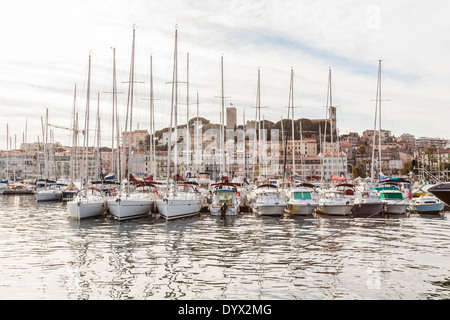 Luxus-Yachten und Motorboote vor Anker im Hafen von Cannes während eines MIPIM-Ausstellung mit der Altstadt im Hintergrund Stockfoto