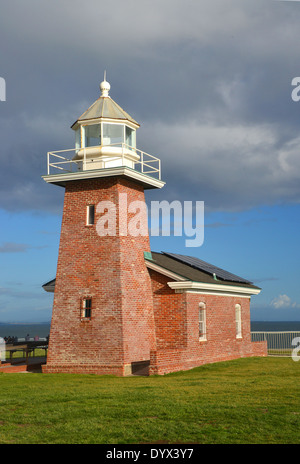 Surfer Museum und Leuchtturm. Das Museum steht auf einer hohen Klippe mit Blick auf eine Wasserfläche, die Surfer anzieht. Stockfoto