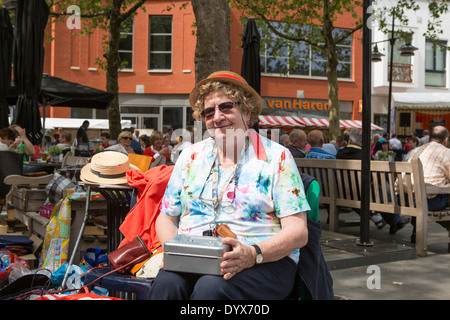 Frau kümmert sich um das Geld auf dem freien Markt von Helmond in den Niederlanden am Königstag. Stockfoto