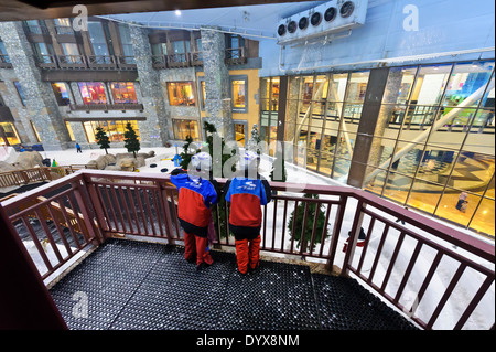 Zwei Kinder stehen auf dem Balkon blickte auf Schnee in der Skihalle zurückgreifen in Dubai, Vereinigte Arabische Emirate, UAE. Stockfoto