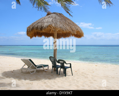 Liegestühle unter Palapa an einem tropischen Strand, Akumal, Karibikküste, Mexiko Stockfoto