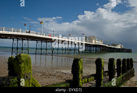 Aussicht auf den Strand bei Ebbe durchsehen alte verwitterte Steg Beiträge zum langen Pier mit zwei Art-déco-Gebäuden an einem sonnigen Tag Stockfoto