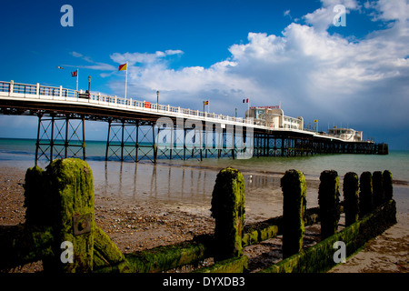 Aussicht auf den Strand bei Ebbe durchsehen alte verwitterte Steg Beiträge zum langen Pier mit zwei Art-déco-Gebäuden an einem sonnigen Tag Stockfoto