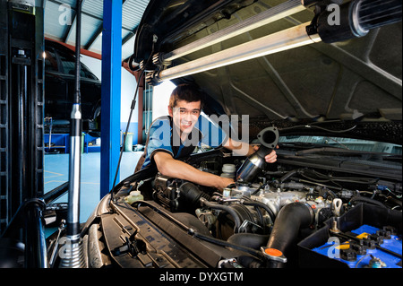 Lehrling Mechaniker unter Motorhaube Stockfoto